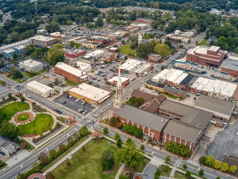 Aerial view of a small downtown with streets, buildings, and a church steeple.