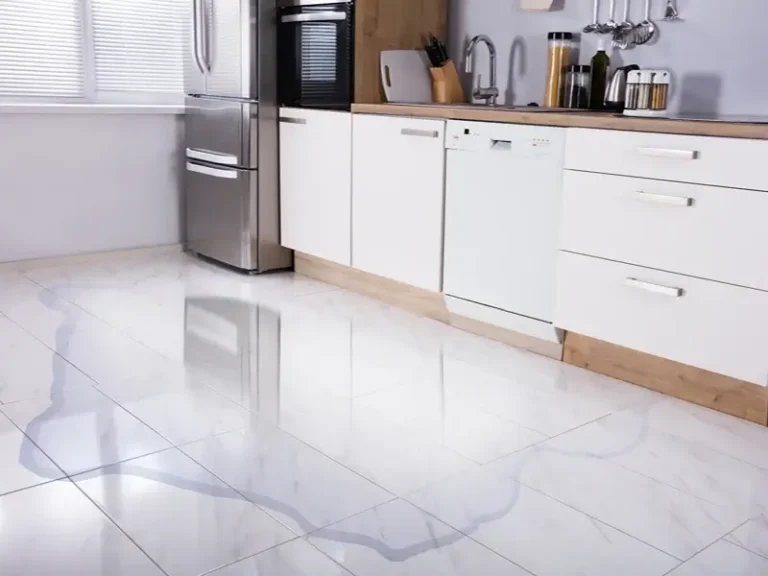 Modern kitchen with glossy white tile floor and stainless steel appliances.